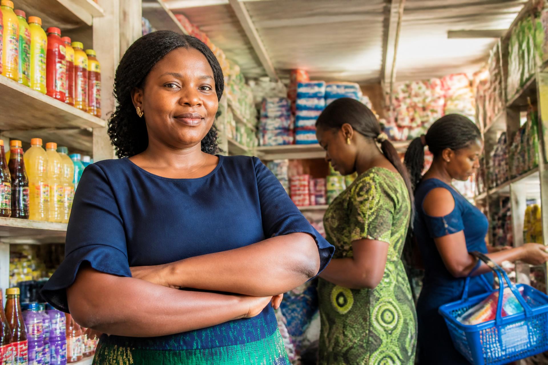 Nigerian shop owner welcoming customers into her business